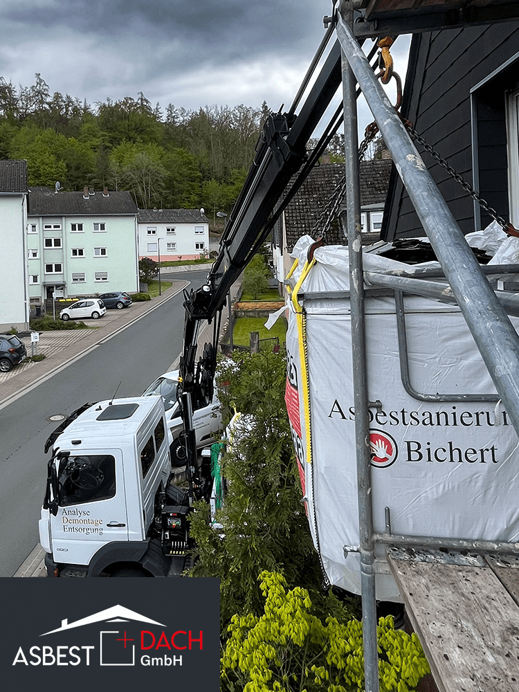 Asbestsanierung vor Ort mit Kran und Big Bag – Entsorgung durch Fachbetrieb Bichert + Dach GmbH an Wohngebäude.
